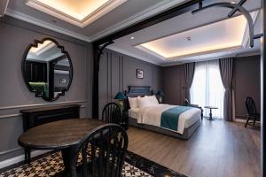 头顿Kim Minh Boutique的酒店客房配有一张床铺和一张桌子。