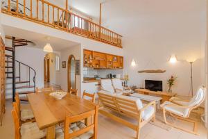 福尔内利斯Tramontana 115 P1的厨房以及带木桌和椅子的客厅。