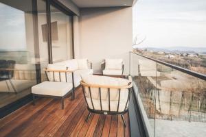 多博沃Villa Vajta的阳台配有两把椅子和一张桌子,还有一个窗户。