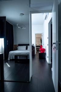 拉奎拉My Suite Hotel的一间卧室配有一张床和一张红色椅子