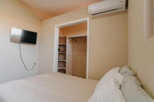 瓜达鲁佩镇Casa Primavera/ Valle de Guadalupe的卧室配有一张床,墙上配有电视。