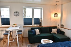 哈普萨卢Kristella Kesklinna Apartment的客厅配有绿色沙发和桌子