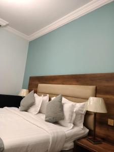 塔伊夫Fiori Resort的一间卧室配有带白色床单和枕头的床。