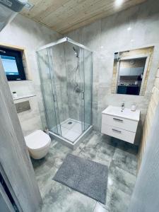 詹塔尔Luksusowe Domki Kalimera的带淋浴、卫生间和盥洗盆的浴室
