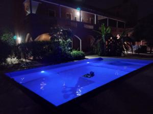 土巴迪亚劳比格博凯旅舍的夜间在院子里设有蓝色灯光的游泳池