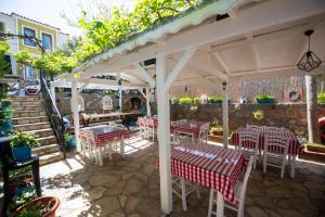 博兹贾阿达岛Ebruli Hotel的一个带桌椅的白色遮阳伞下庭院