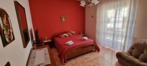 锡拉库扎Casa Lucia的一间卧室设有一张床和红色的墙壁