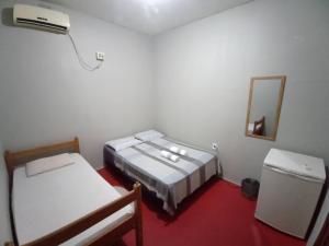 马瑙斯Discovery hostel的小房间设有两张床和镜子