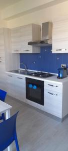 莱圭利亚Jak's Home Laigueglia的厨房配有白色橱柜和炉灶烤箱。