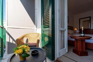 尼亚卢卡Hotel Dalmacija的一个带桌子的阳台和一间带床的房间