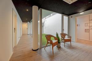 波尔图Uporto House Residence的走廊设有两把椅子和大窗户