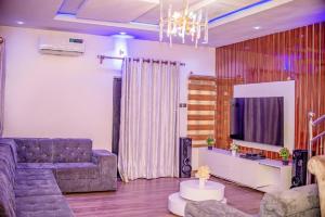 拉各斯Luxury 3-Bedroom Duplex FAST WIFI & 247Power的带沙发和电视的客厅