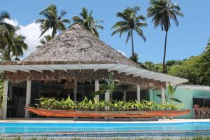 纳玛塔库拉芒果湾度假村的一个带游泳池和茅草屋顶的度假胜地