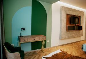 斯库台Centropolis Apartments的一间设有绿色墙壁、书桌和电视的客房