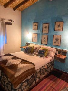 卡奇Casa de Campo La Paya的一间卧室设有一张蓝色墙壁的大床
