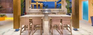 巴亚尔塔港LOS MUERTOS BEACH SUITE 101的厨房配有带藤椅的大桌子