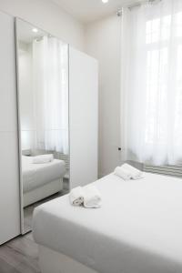 米兰LA CORTE LUXURY APARTMENT的白色的客房配有两张床和镜子