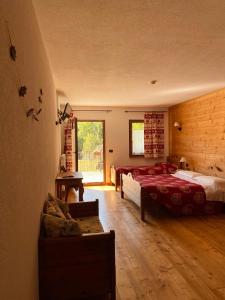 利莫内皮埃蒙特阿尔堤辛酒店的一间卧室配有两张床和一张沙发。