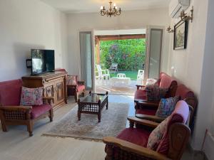 Dawwār Abū MaḩrūsCheerful fully furnished 3 bedroom villa in North Coast的带沙发、椅子和电视的客厅