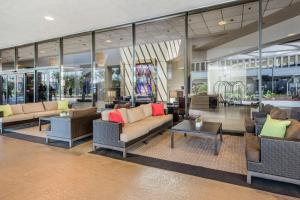 洛杉矶Sonesta Los Angeles Airport LAX的大堂配有沙发、桌子和窗户。