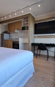 奇廉Apart Hotel Las Terrazas Suite的一间卧室配有一张床,厨房配有书桌
