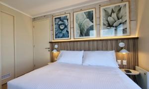 奇廉Apart Hotel Las Terrazas Suite的卧室配有一张白色床,墙上挂有照片