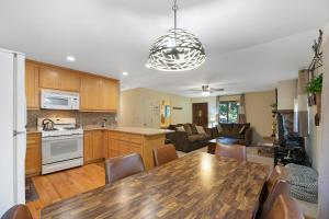 南太浩湖Atroari Adventures的厨房以及带木桌和椅子的客厅。