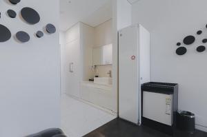 光州ACC设计酒店的白色的厨房配有冰箱和水槽