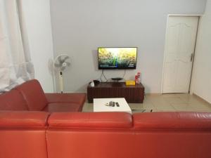 洛美HEBERTOGO TOKOIN CASABLANCA的客厅配有红色沙发和平面电视