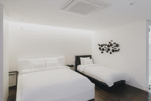 光州ACC设计酒店的白色墙壁客房的两张床