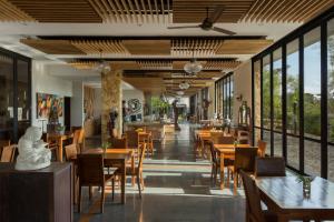 塞米亚克塞米亚克百丽宫酒店的餐厅设有木桌、椅子和窗户。
