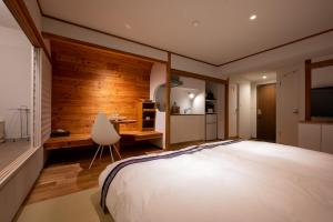 野沢卡晚图亚酒店的一间卧室配有一张床、一张桌子和一把椅子