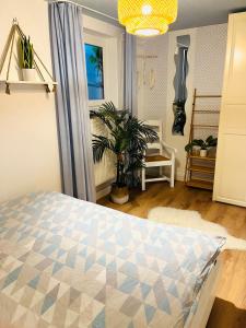 波茨坦Extravagantes Apartment的一间卧室配有一张床和盆栽植物