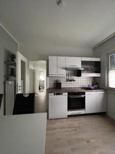 吉森Ferienhaus-Ost的厨房配有白色橱柜和炉灶烤箱。