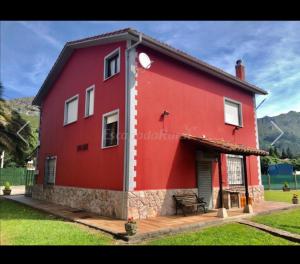 坎加斯-德奥尼斯Casa La Granda的前面有长凳的红色房子