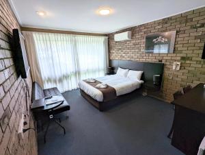 本迪戈霍姆斯特汽车旅馆和公寓酒店的一间卧室配有一张床和一张书桌