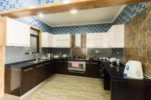 内罗毕Shayona Apartments Limited的厨房配有白色橱柜和蓝色瓷砖