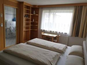 EhenbichlWei Wei's Hostel的一间卧室设有两张床、一个窗口和一张桌子