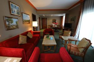 布罗马纳普林坦尼亚宫殿酒店的客厅配有红色的沙发和桌子