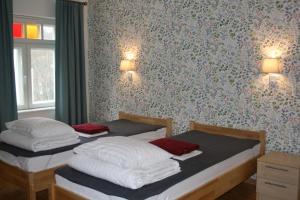 沃索Posti Villa的卧室内的两张床,带鲜花的墙壁