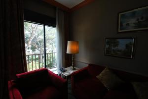 布罗马纳普林坦尼亚宫殿酒店的客厅设有红色的沙发和窗户。