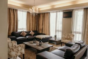 斯瓦科普蒙德Artemis Hotel Swakopmund的客厅配有黑色真皮沙发和椅子