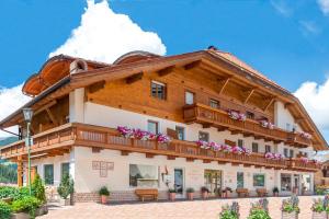 拉瓦莱Hotel Alpenrose Dolomites的一座带鲜花的大木结构建筑,阳台上