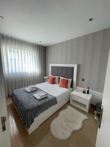 马亚OPORTO House AL的卧室配有带红色枕头的大型白色床