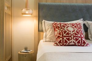 罗希姆诺C Suites的一张带红色枕头和蓝色床头板的床