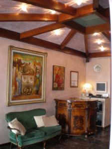 塞尔维诺马尔切利诺酒店的客厅配有绿色沙发和墙上的绘画
