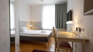 LundsbrunnLundsbrunn Resort & Spa的一间卧室配有一张床、一张桌子和一张书桌