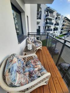 耶莱尼亚古拉Apartament Mazurek的阳台的甲板上配有2把藤椅