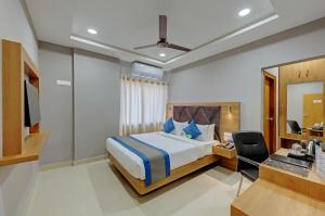 古瓦哈提Click Hotel Guwahati的一间卧室配有一张床、一张书桌和一面镜子