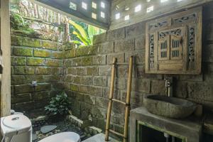 贾蒂卢维Tepi Sawah Lodge & Retreat的石质浴室设有水槽和卫生间